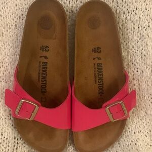 Women’s Birkenstock sandals with one pink patent leather buckled strap, size 11.